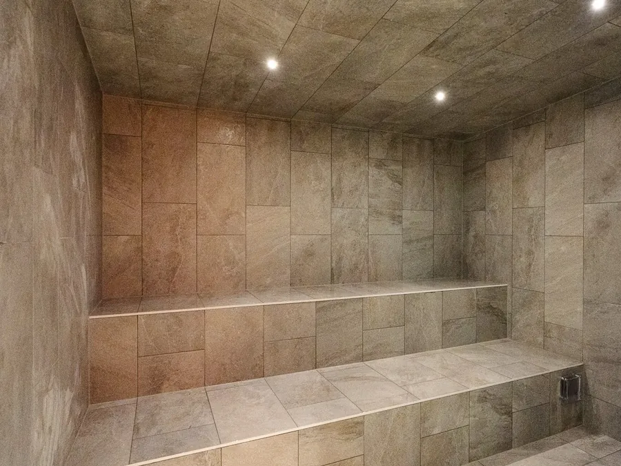 Tiled steam room with tiered seating at a commercial wellness centre